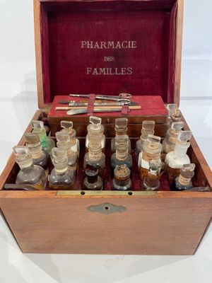 an old wooden box filled with bottles of different types of medicine