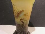 a glass vase with a dragon on it on a table