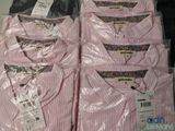 many pink shirts on display in a store