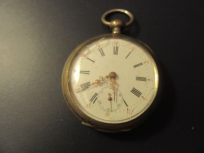 clock with roman numerals on the face on a black surface