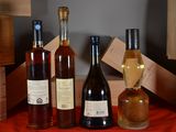 several bottles of wine are lined up on a red table cloth
