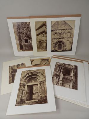 cinq vieilles photographies représentant un bâtiment et une entrée sont disposées sur une table