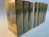 six books in a row on a table with a white background