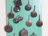 une photo d'une collection de casseroles et de poêles accrochées au mur