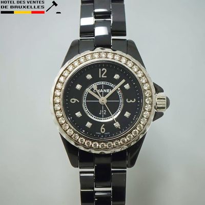 une photo d'une montre noire dont la lunette est sertie de diamants