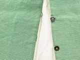 the back of a green shirt with buttons on it