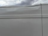 a white van parked in a parking lot under a cloudy sky