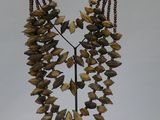 a necklace made of yellow and brown stones on a stand