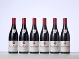 six bottles of red wine lined up in a row
