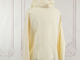 yellow hoodie on a mannequin stand in front of a white wall