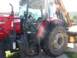 a red tractor that is parked in the grass
