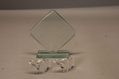 un petit trophée en verre posé sur un socle, sur une table