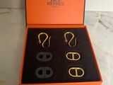 an orange box containing three pairs of earrings and a pair of scissors
