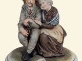 a figurine of a man and a woman sitting on a bench