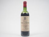 une vieille bouteille de vin posée sur une surface blanche