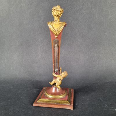brass and red clock with a statue of a man holding a child