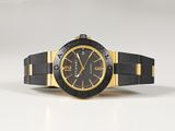 black and gold watch on a white surface with a white background