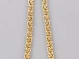 a gold chain necklace with a clasp on a white background