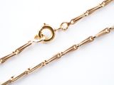 a close up of a gold chain with a clasp on a white background