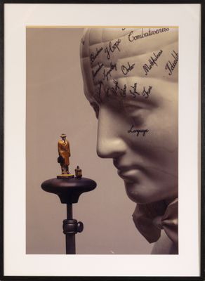 photo encadrée représentant la statue d'un homme avec une inscription sur la tête