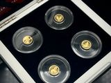 Quatre pièces d'or se trouvent dans une vitrine posée sur une table