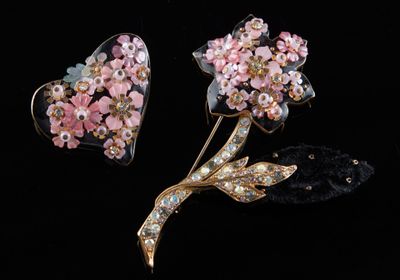 deux fleurs roses et une broche en forme de cœur sur fond noir