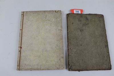 un vieux livre posé sur une table blanche, à côté d'un livre plus petit