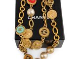 a close up of a bracelet with pearls and charms on it
