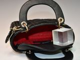 a small black purse with a clear block inside of it
