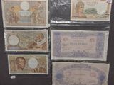 six billets de banque différents sont disposés sur une surface noire