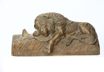 statue d'un lion posé sur un rocher, tenant un oiseau dans sa gueule