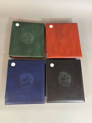 four different colored notebooks sitting on top of a white surface