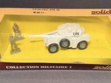 toy army vehicles are in a box on a gray surface
