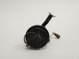 an old fishing reel on a white surface