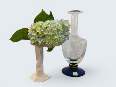 two vases with flowers in them sitting next to each other
