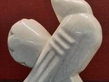 a white sculpture of a bird sitting on a table