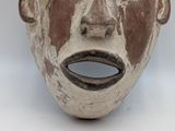 a close up of a clay mask on a white surface