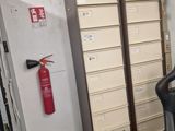 a black office chair sitting in a room with a fire extinguisor