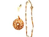 une photo d'un collier et d'une broche sur fond blanc