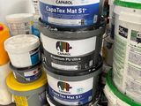 several buckets of paint are stacked on a pallet in a warehouse