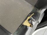 the seat of a car with a piece of paper sticking out of it