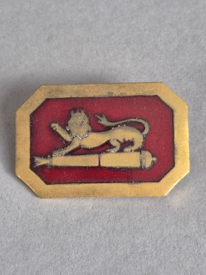 un gros plan sur un insigne doré et rouge orné d'un lion