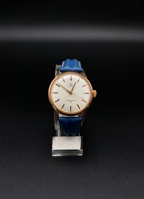 une montre dorée et bleue posée sur une surface noire
