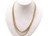 un collier en or sur un mannequin, sur fond blanc