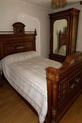 un lit avec une tête de lit en bois et un miroir accroché au mur