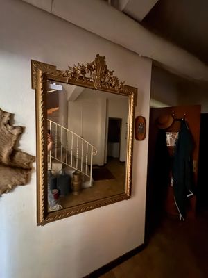 un miroir accroché au mur, à côté d'un mur sur lequel est posé un ours en peluche
