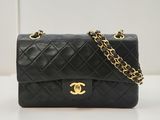 un sac Chanel noir posé sur une table blanche
