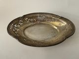 an antique silver plate with a flower design on the rim