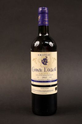 une bouteille de vin posée sur une table à côté d'une bouteille de vin