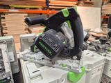 a green and black circular saw on top of a white box